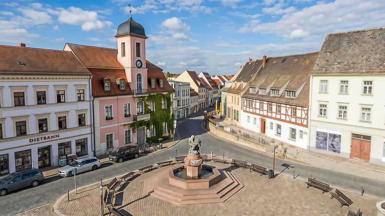 Wurzener Marktplatz mit historischem Brunnen, der Stadtkirche und Bürgerhäusern aus Klassik und Gründerzeit.